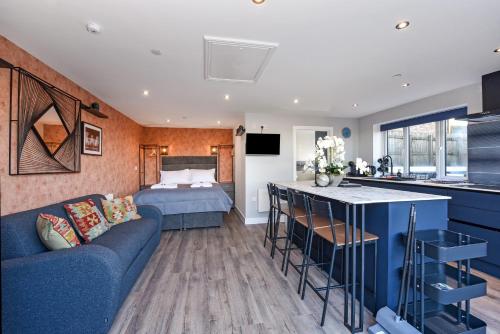 ein Wohnzimmer mit einem blauen Sofa und einem Bett in der Unterkunft La Cantera in Merthyr Tydfil