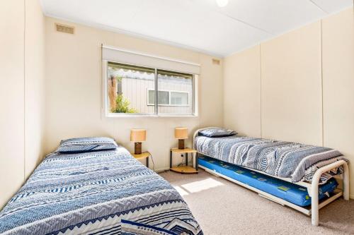 Duas camas num quarto com uma janela em Ventnor Getaway em Ventnor