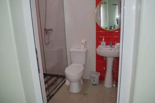 a bathroom with a toilet and a sink at Comfortable and Cozy Apartments in Praia
