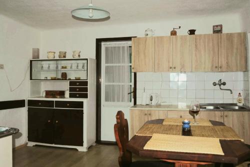 Una cocina con una mesa de madera y un comedor. en Family friendly house with a parking space Zakrajc Brodski, Gorski kotar - 20569, en Brod na Kupi