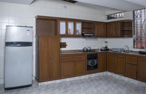 a kitchen with wooden cabinets and a white refrigerator at villa de las palmas in Palmira