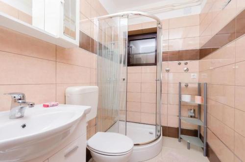 a bathroom with a toilet and a sink and a shower at Apartments Nenad in Dramalj