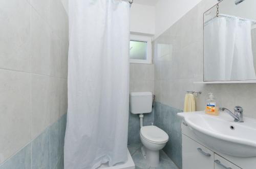 a bathroom with a white shower curtain and a toilet at Apartment Anica in Kampor