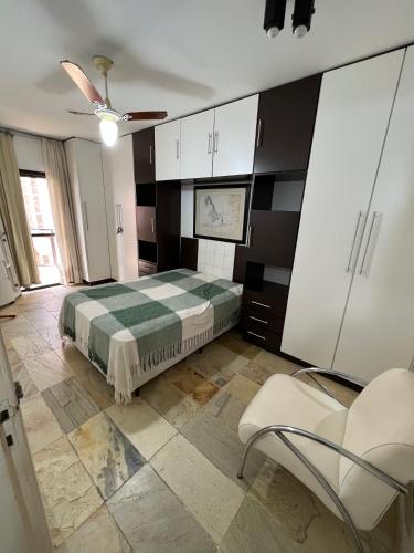 1 dormitorio con 1 cama y 1 silla en Apto Completo com vista para o Mar e Wi-Fi 300MB, en Guarapari