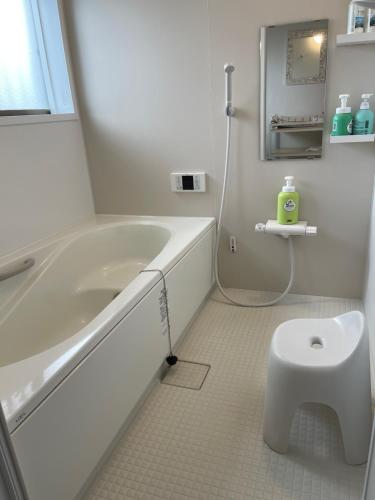 a white bathroom with a tub and a toilet at Children's cafe B&B Kimie in Kamakura