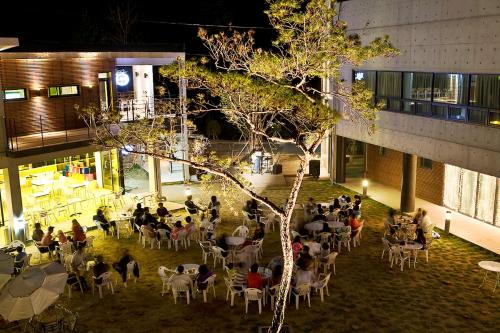 a group of people sitting at tables in a courtyard at night at Hyundai Soo Resort Hoengseong in Pyeongchang 