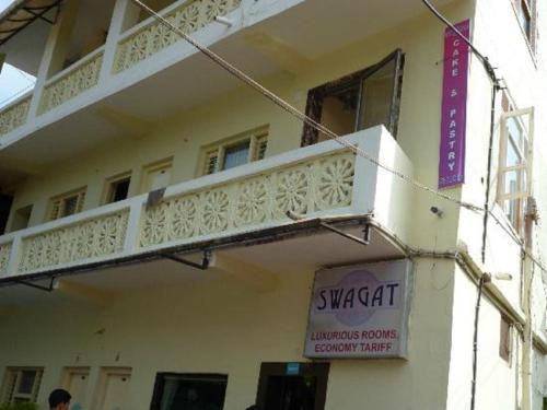 a building with a balcony and a sign on it at Hotel Swagat in Mount Ābu