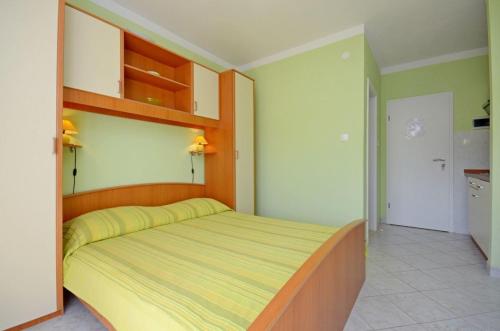 Schlafzimmer mit einem Bett mit einem Kopfteil aus Holz in der Unterkunft Apartments Vesna in Lastovo