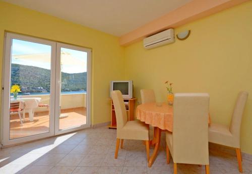 a dining room with a table and a balcony at Apartments Vesna in Lastovo