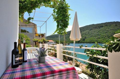 a table with two bottles of wine sitting on a balcony at Apartments Slavica in Ubli