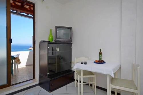 uma sala de jantar com uma mesa e uma televisão por cima em Apartments and Rooms Barbara em Lastovo