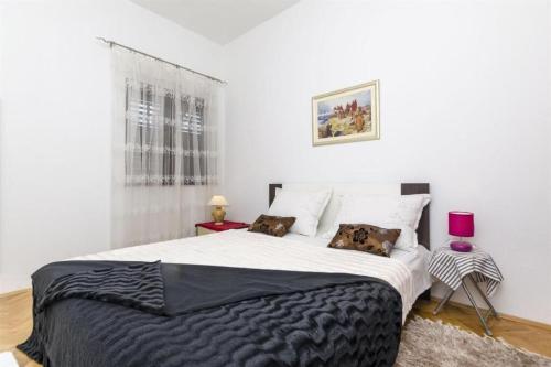 sypialnia z dużym łóżkiem z czarnym kocem w obiekcie Apartment Zvonimir w mieście Sumpetar