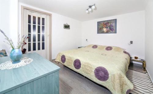 a bedroom with a bed and a vase on a table at Apartment Sanja in Martina