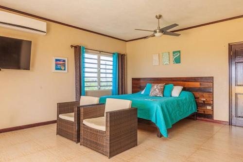 a bedroom with a bed and chairs and a flat screen tv at The Junior Suite's "Palm Studio Apartment" in South Hill Village