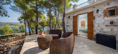 a patio with chairs and a table with a television at House Vesna Kupinova in Milna