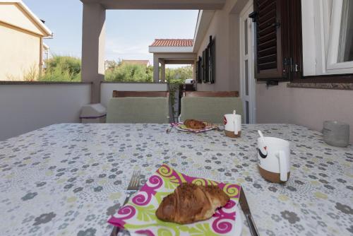 einen Tisch mit einem Teller Essen drauf. in der Unterkunft Apartments Max in Ražanac