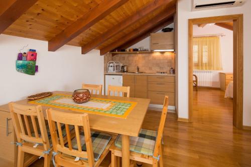 cocina y comedor con mesa de madera y sillas en Apartment Zlendic en Gornje Selo