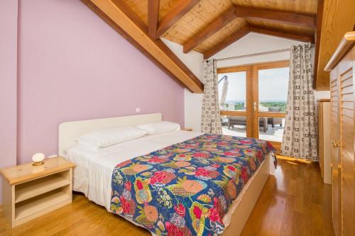1 dormitorio con 1 cama con una manta colorida en Apartment Zlendic, en Gornje Selo
