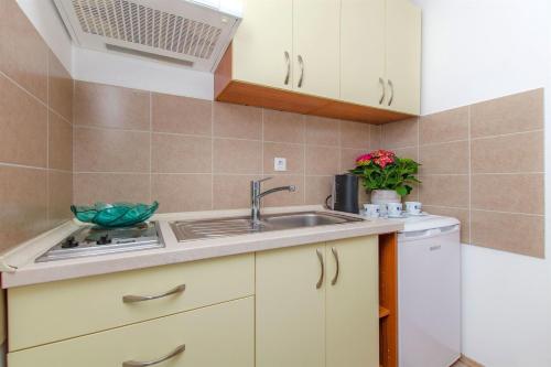 a kitchen with white cabinets and a sink at Apartments Mira in Omiš