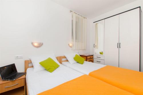 a bedroom with a bed with a laptop on it at Apartments Mira in Omiš