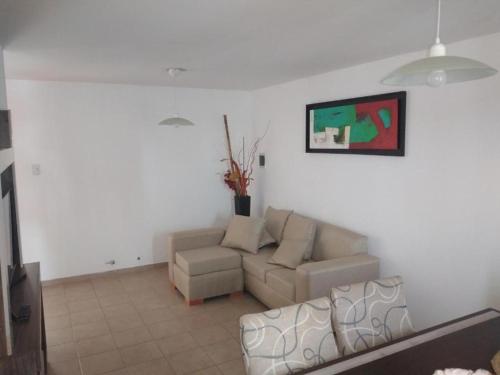 sala de estar con sofá y silla en Olivia Apart frente plaza centro con cochera en Villa María