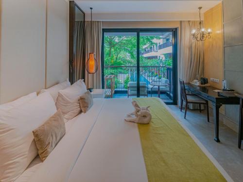 a bedroom with a white couch with a stuffed animal on it at Jambuluwuk Oceano Seminyak Hotel in Seminyak