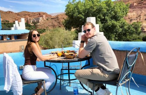a man and a woman sitting at a table with food at Labyrinth Kasbah Dades in Ait Ben Ali