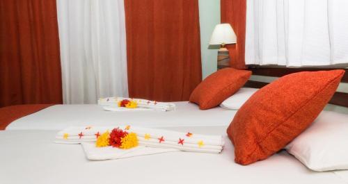 two beds with white sheets and red pillows at Apartamentos Palo Coco in Las Terrenas