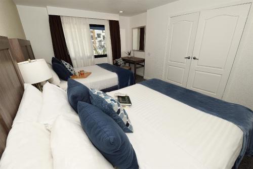 a bedroom with two beds with blue pillows at Serene Vegas Boutique Hotel Las Vegas in Las Vegas