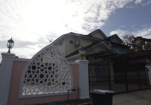 a house with a gate and a fence at Homestay Rumah Singgah in Jitra