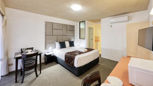 Pokój hotelowy z łóżkiem, stołem i biurkiem w obiekcie City Reach Motel w mieście Wangaratta