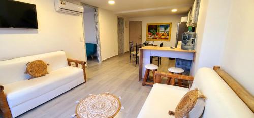 sala de estar con sofá blanco y mesa en Apartamentos Ingrid, en San Andrés
