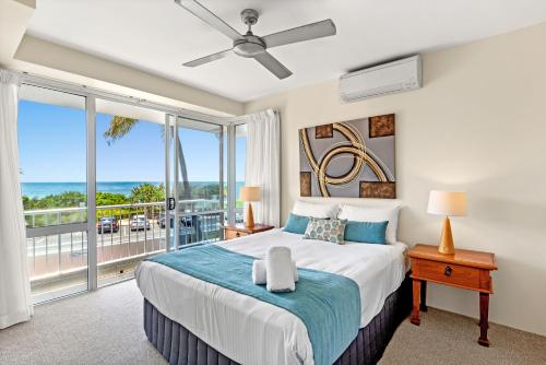 a bedroom with a large bed and a balcony at La Mer Sunshine Beachfront in Sunshine Beach