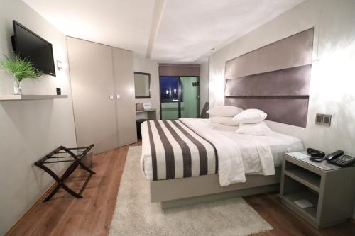 a bedroom with a large bed and a television at Hotel Posada Tulancingo in Tulancingo