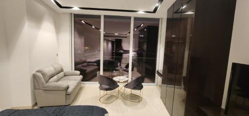 een woonkamer met een bank, stoelen en een tafel bij studio apartment with balcony in Seef