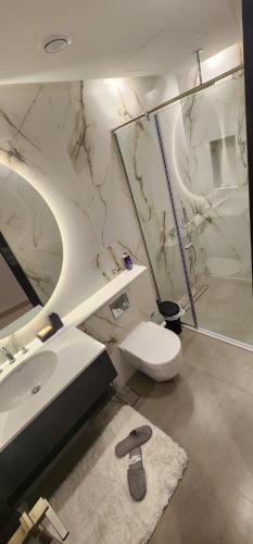 a white bathroom with a sink and a toilet at studio apartment with balcony in Seef
