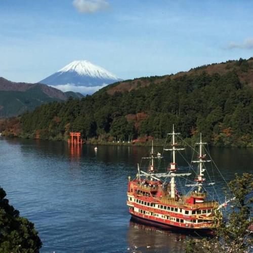a large boat in the water with a mountain in the background at EK House Hakone Shushinso 箱根修身荘 in Onsensō