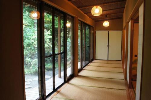 an empty hallway with large windows in a house at EK House Hakone Shushinso 箱根修身荘 in Onsensō