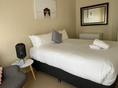 ein Hotelzimmer mit 2 Betten und einem Stuhl in der Unterkunft Units on Robertson in Mudgee