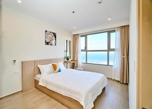 a bedroom with a large bed and a large window at The Sóng Apartment Vũng Tàu - Green House in Vung Tau