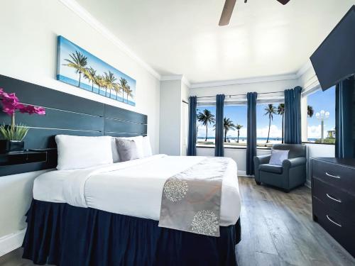 a bedroom with a large bed and a chair at Hollywood Beach Hotels in Hollywood