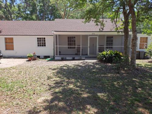 a white house with a tree in front of it at Southside Jax great home RV parking in Jacksonville