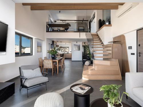 a living room with a staircase and a dining room at Sea & Sun Penthouse in Chania