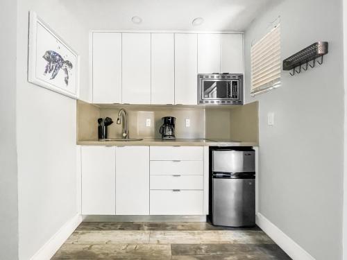 a kitchen with white cabinets and a stainless steel appliance at Hollywood Beach Hotels in Hollywood