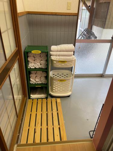 einen kleinen begehbaren Kleiderschrank mit einer Bank und Handtüchern in der Unterkunft FRIENDS in Futae