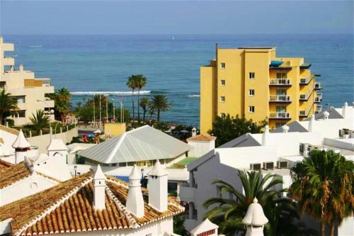 vistas a una ciudad con edificios y al océano en Hotel Betania, en Benalmádena