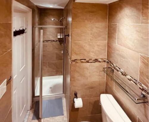 een badkamer met een douche, een toilet en een bad bij Cozy Apartments close to New York City in North Bergen