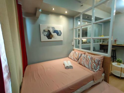 a small bedroom with a bed with a window at Tagaytay Wind Residences in Tagaytay