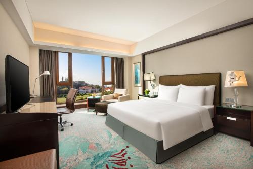 a hotel room with a bed and a living room at Xiamen C&D Hotel-Free Welcome Snacks-Oasis Garden in Xiamen