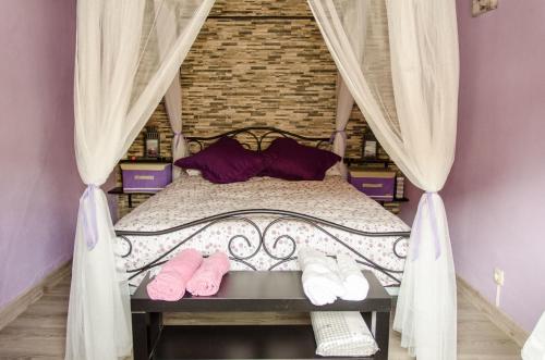um quarto com uma cama com chinelos cor-de-rosa em El Rincón de Burujón em Burujón